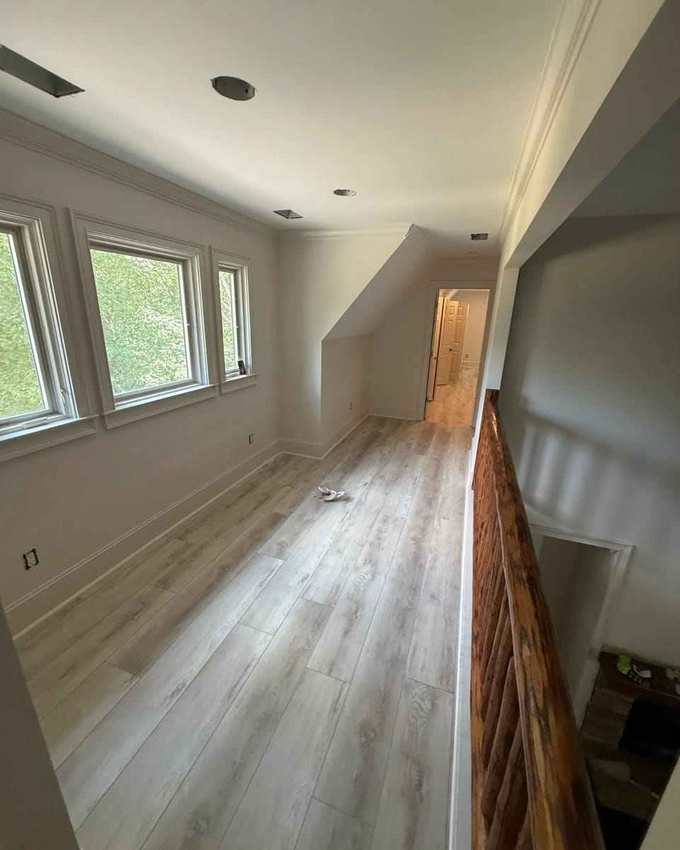 Stairwell landing with white painted walls and window trim, cut clean at the ceiling line